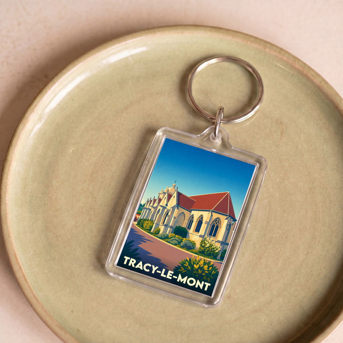 Porte-clés souvenir de la ville de Tracy-le-Mont avec une illustration stylisée de son église.