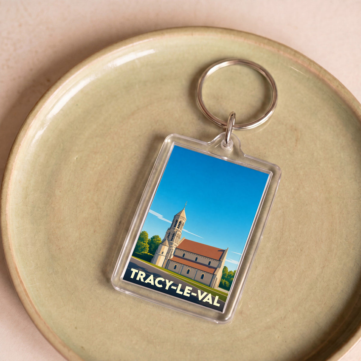 Porte-clés souvenir de la ville de Tracy-le-Val avec une illustration stylisée de son église.