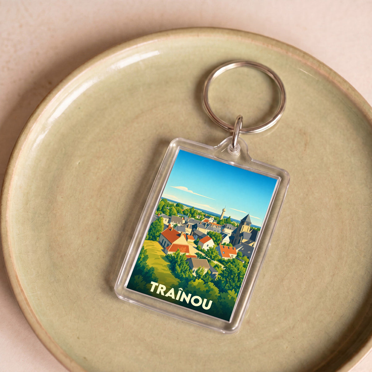Porte-clés souvenir de la ville de Traînou avec une illustration stylisée.