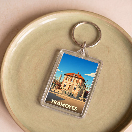 Porte-clés souvenir de la ville de Tramoyes avec une illustration stylisée.