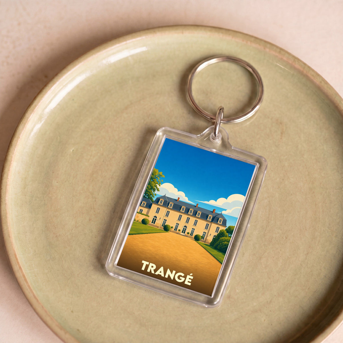Porte-clés souvenir de la ville de Trangé avec une illustration stylisée d'un château.