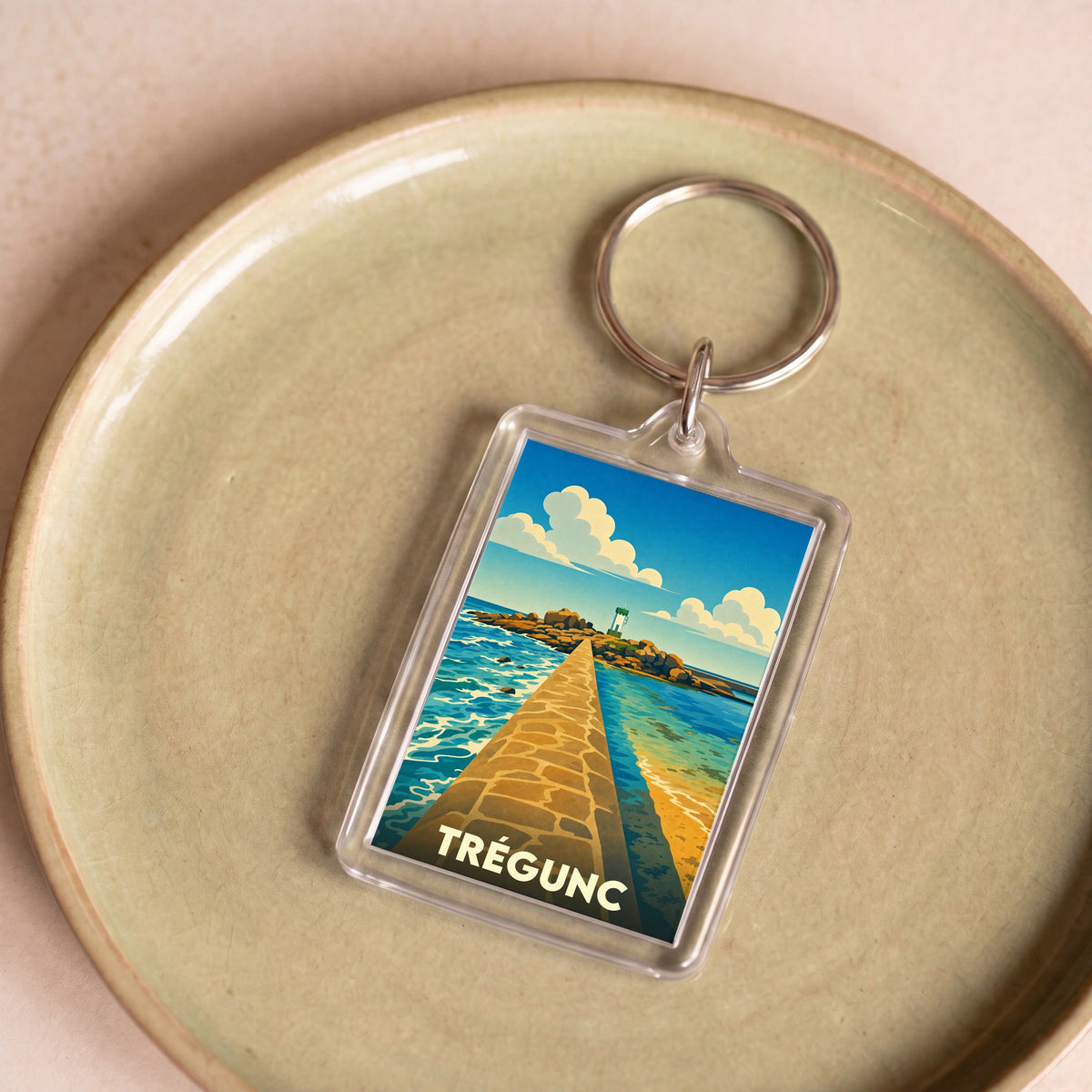 Porte-clés souvenir de la ville de Trégunc avec une illustration stylisée d'un littoral breton.