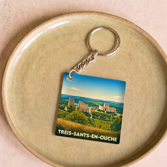 Porte-clés souvenir de la ville de Treis-Sants-en-Ouche avec une illustration stylisée d'un paysage historique.
