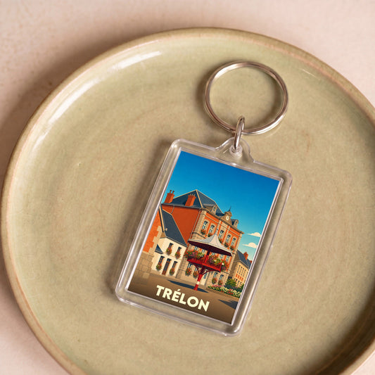 Porte-clés souvenir de la ville de Trélon avec une illustration stylisée de son architecture.