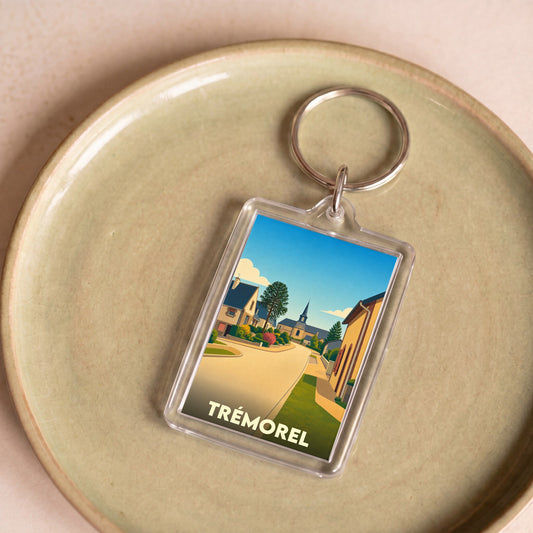 Porte-clés souvenir de la ville de Trémorel avec une illustration stylisée.