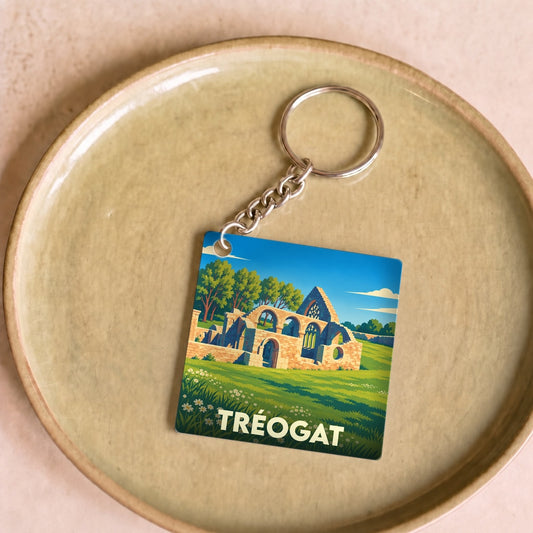 Porte-clés souvenir de la ville de Tréogat avec une illustration stylisée de ruines historiques.