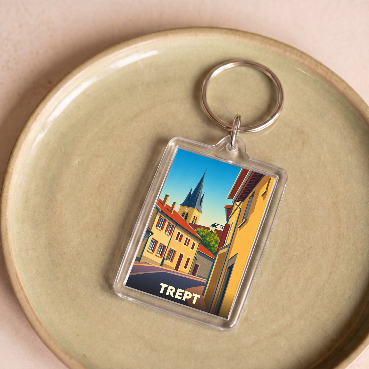 Porte-clés souvenir de la ville de Trept avec une illustration stylisée de ses bâtiments et de son clocher.