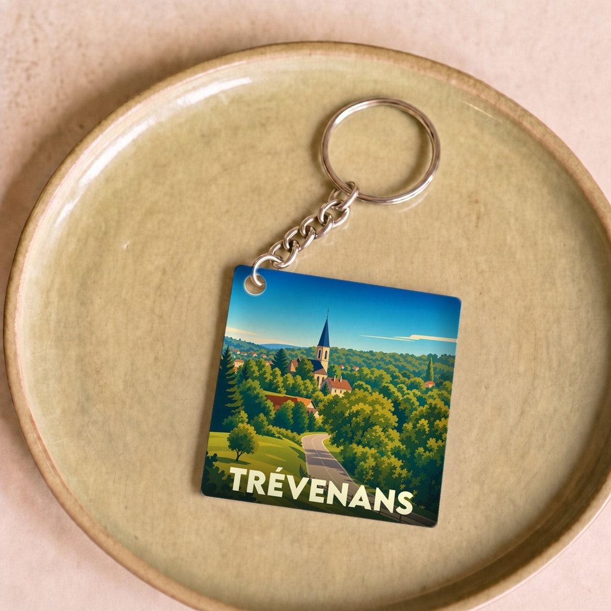 Porte-clés souvenir de la ville de Trévenans avec une illustration stylisée.