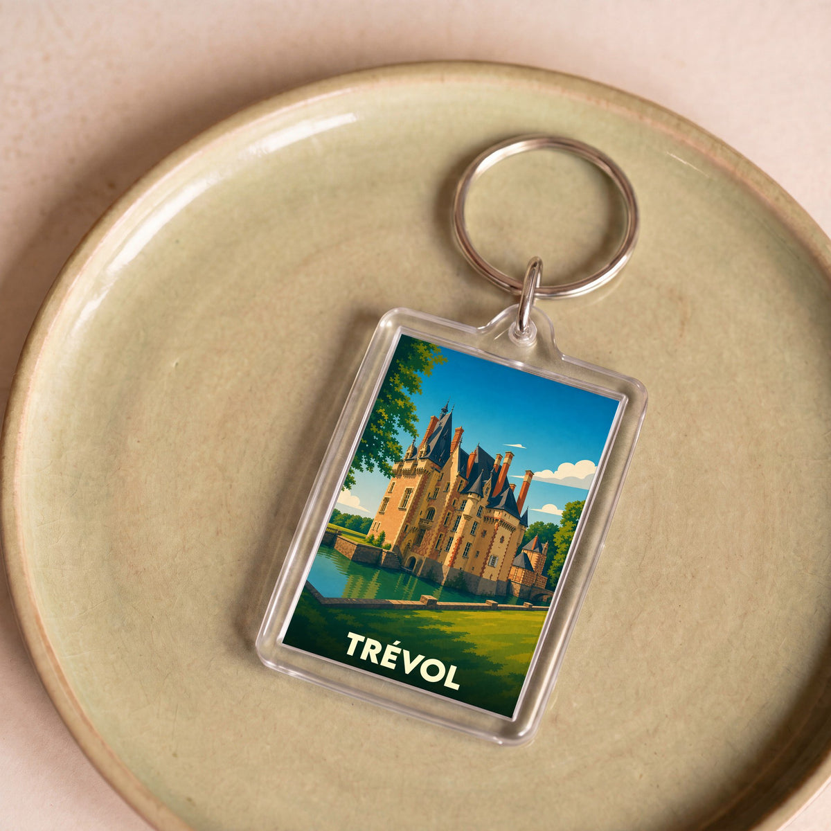 Porte-clés souvenir de la ville de Trévol avec une illustration stylisée de son château.