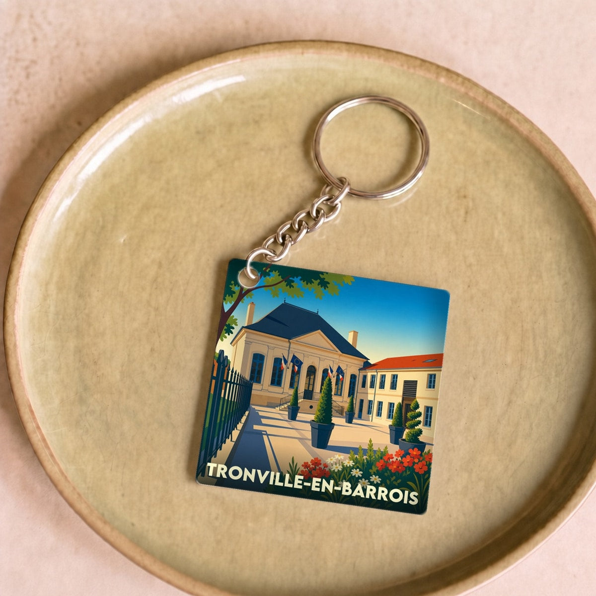 Porte-clés souvenir de la ville de Tronville-en-Barrois avec une illustration stylisée de son hôtel de ville.