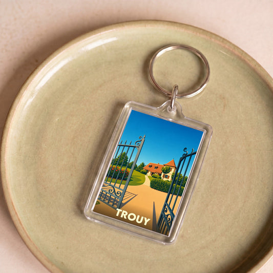 Porte-clés souvenir de la ville de Trouy avec une illustration stylisée d'une propriété.