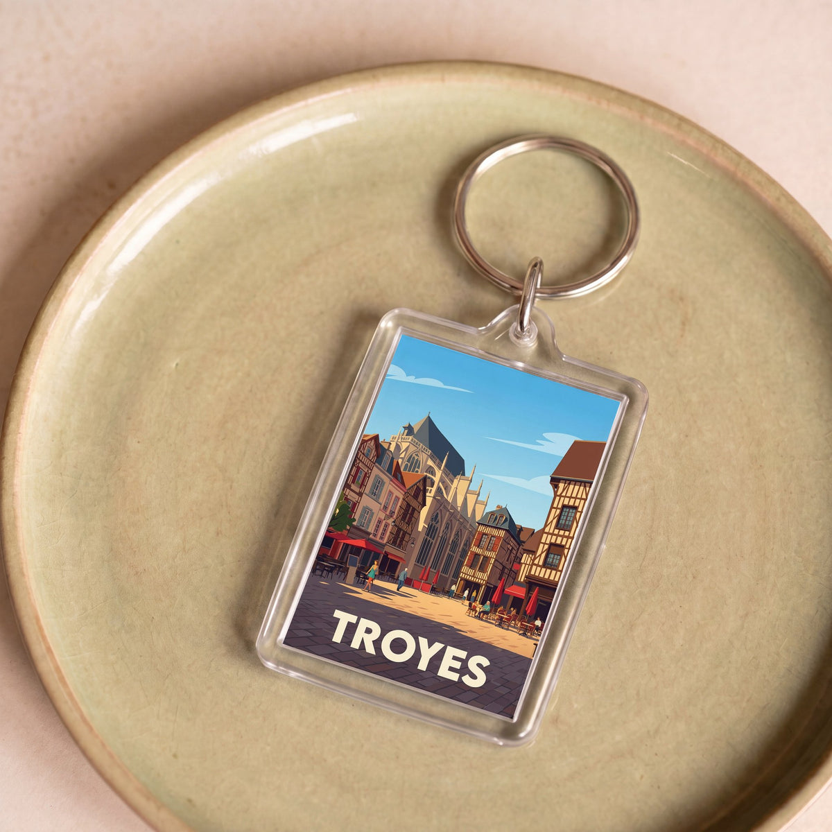 Porte-clés souvenir de la ville de Troyes avec une illustration stylisée de son architecture historique.