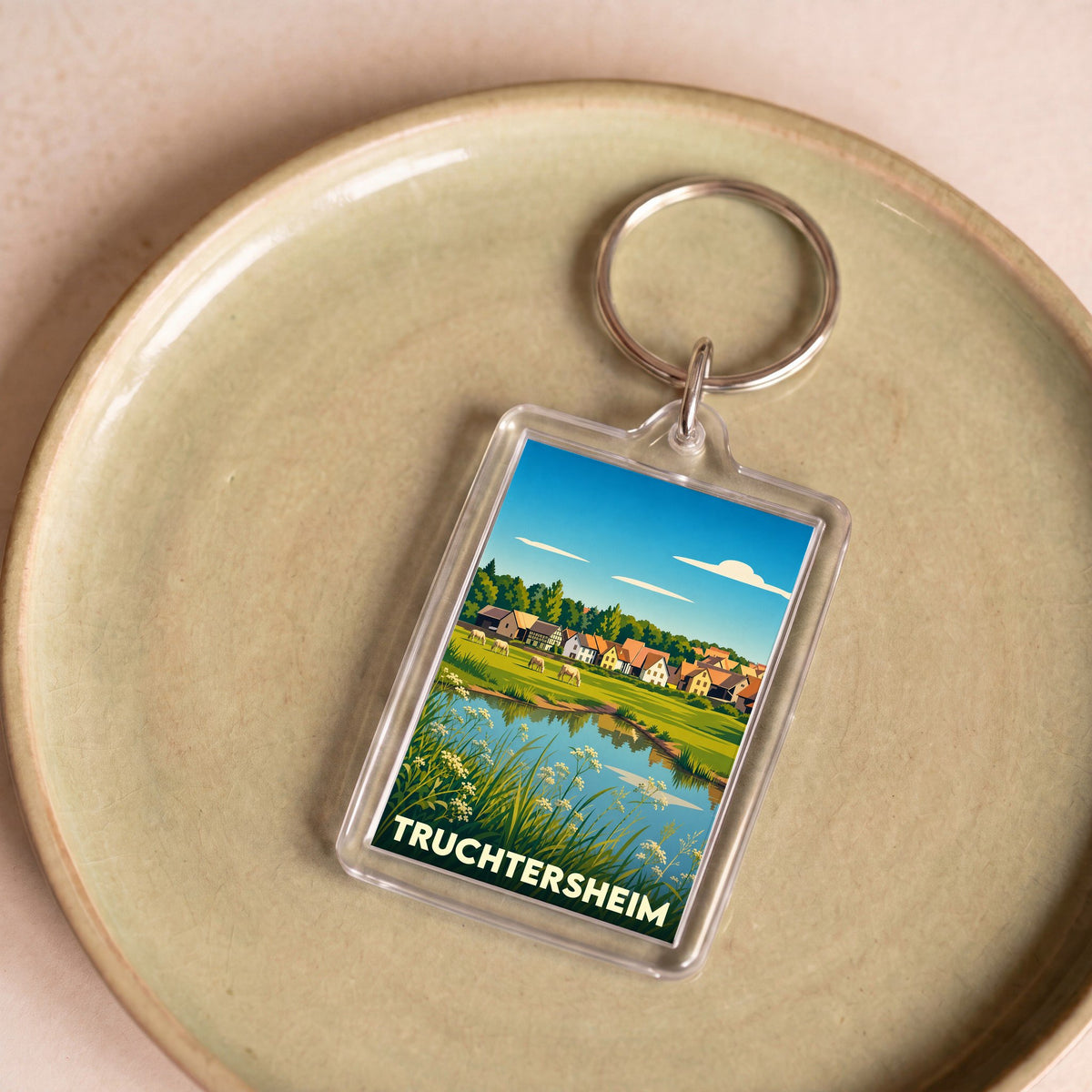 Porte-clés souvenir de la ville de Truchtersheim avec une illustration stylisée de son paysage champêtre.
