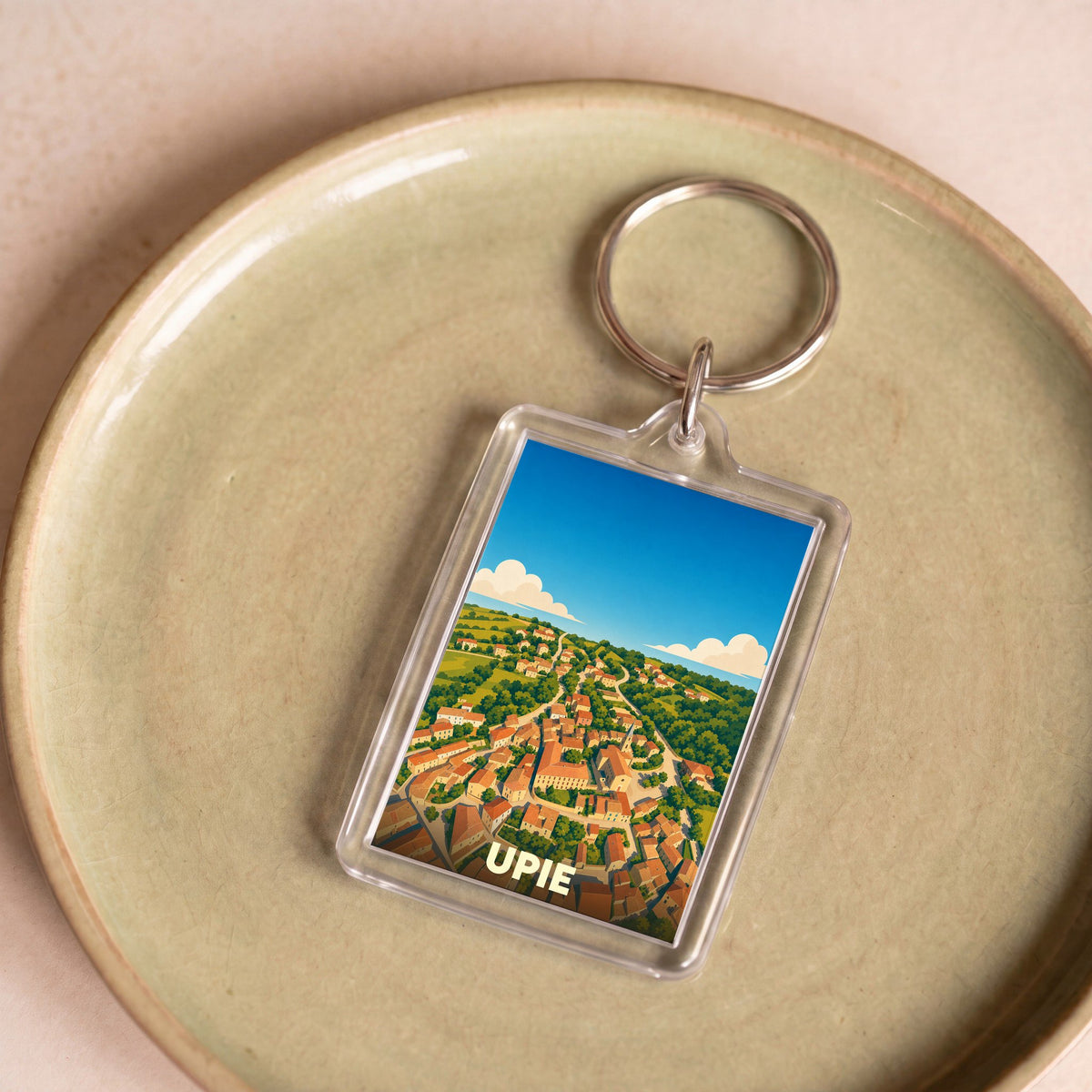 Porte-clés souvenir de la ville d'Upie avec une illustration stylisée vue du ciel.