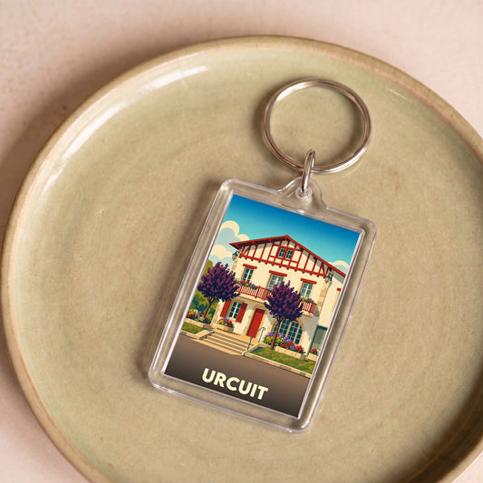 Porte-clés souvenir de la ville de Urcuit avec une illustration stylisée.