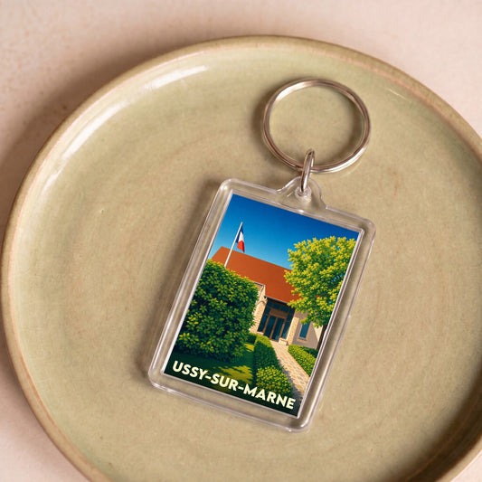 Porte-clés souvenir de la ville de Ussy-sur-Marne avec une illustration stylisée.