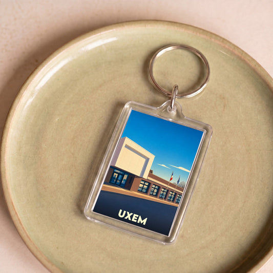 Porte-clés souvenir de la ville d'Uxem avec une illustration stylisée de sa mairie.