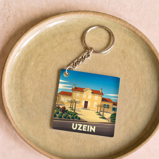 Porte-clés souvenir de la ville d'Uzein avec une illustration stylisée.