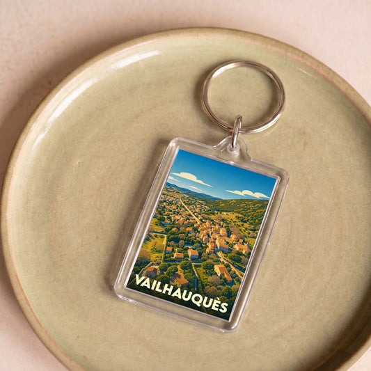 Porte-clés souvenir de la ville de Vailhauquès avec une illustration stylisée.
