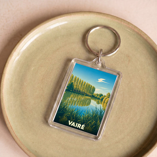 Porte-clés souvenir de la ville de Vairé avec une illustration stylisée d'un paysage naturel.