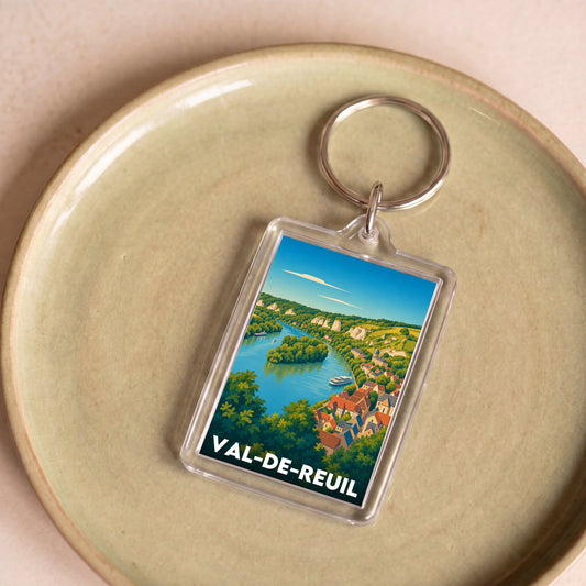 Porte-clés souvenir de la ville de Val-de-Reuil avec une illustration de paysage stylisée.