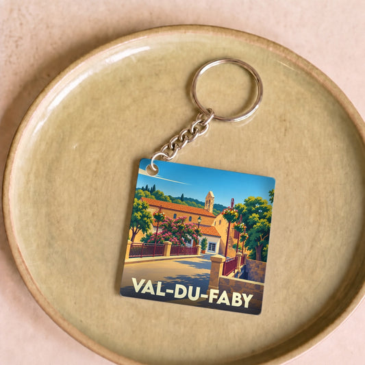 Porte-clés souvenir de Val-du-Faby avec une illustration stylisée d'un village provençal fleuri.