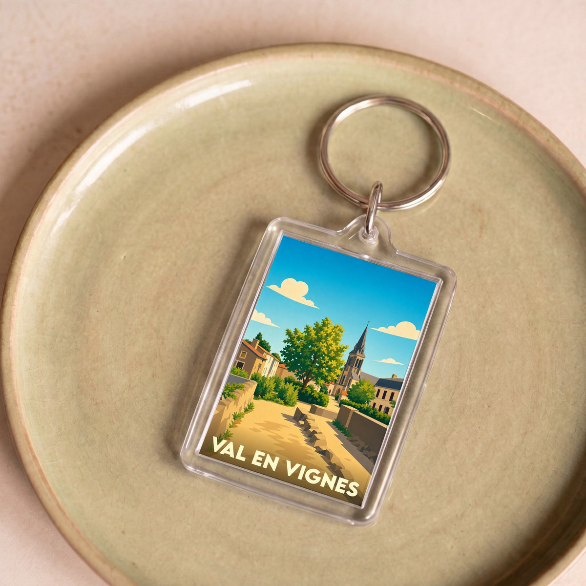 Porte-clés souvenir de la ville de Val en Vignes avec une illustration stylisée.