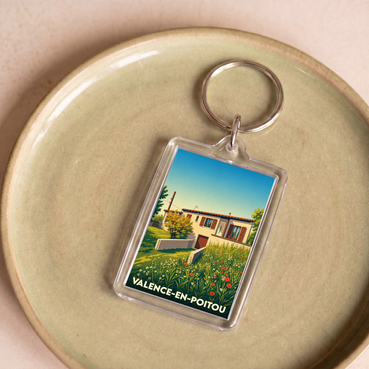 Porte-clés souvenir de Valence-en-Poitou avec une illustration stylisée d'une maison de campagne.