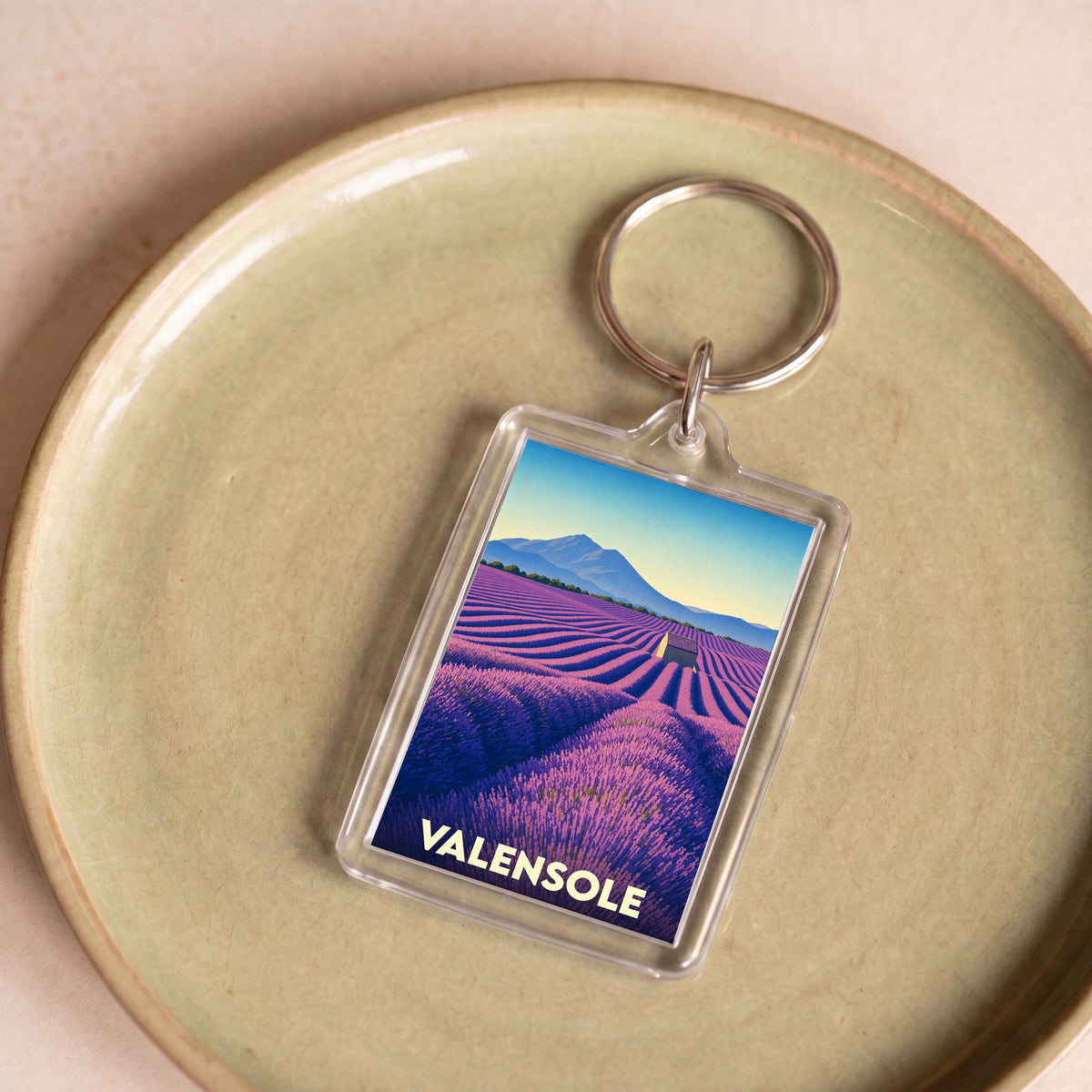 Porte-clés souvenir de la ville de Valensole illustré d'un champ de lavande stylisé.