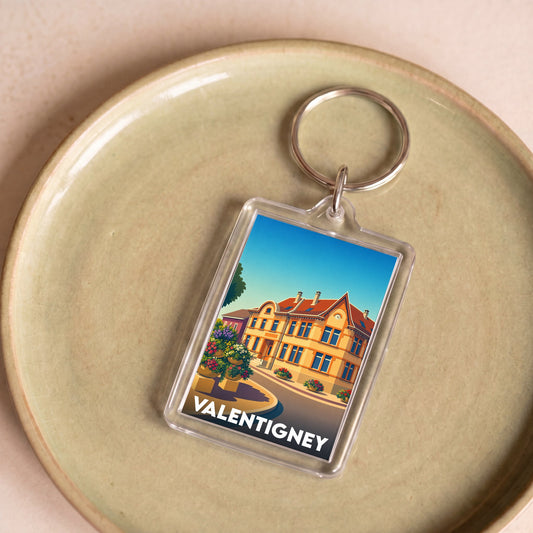 Porte-clés souvenir de la ville de Valentigney avec une illustration colorée et stylisée d'un bâtiment historique.