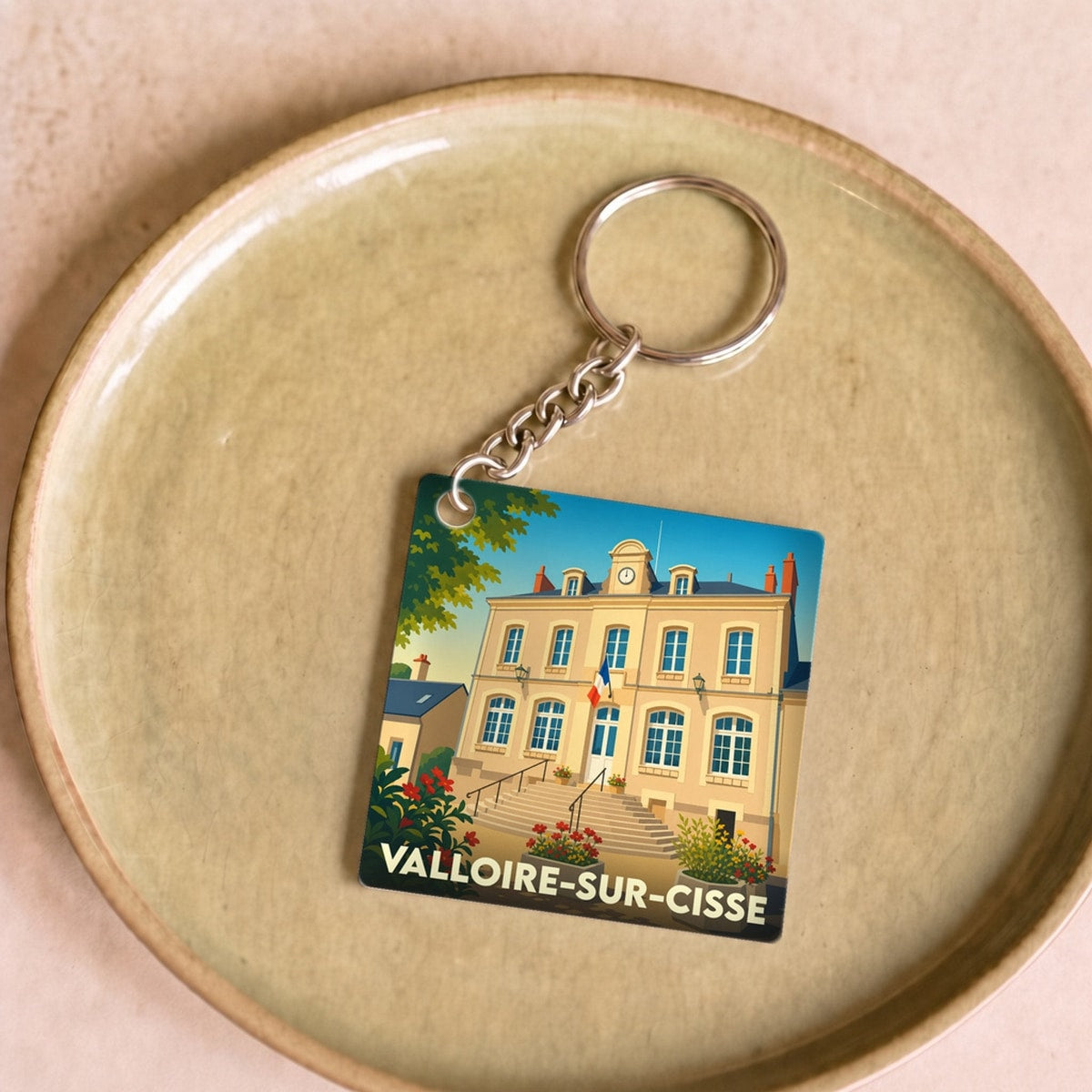 Porte-clés souvenir de la ville de Valloire-sur-Cisse avec une illustration stylisée de sa mairie.
