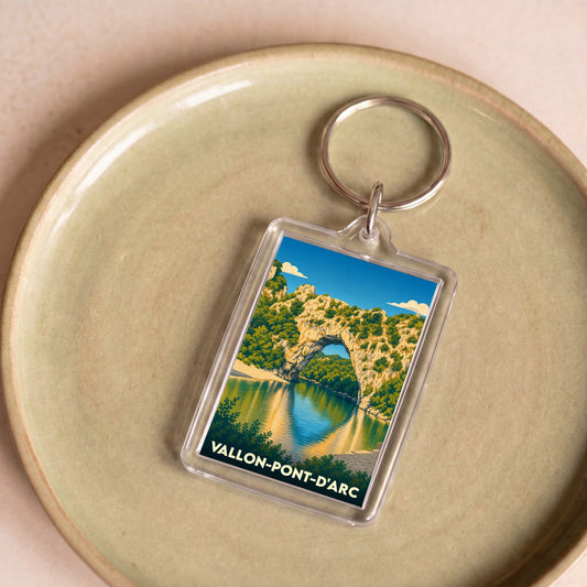 Porte-clés souvenir de la ville de Vallon-Pont-d'Arc avec une illustration stylisée de son célèbre pont naturel en pierre.