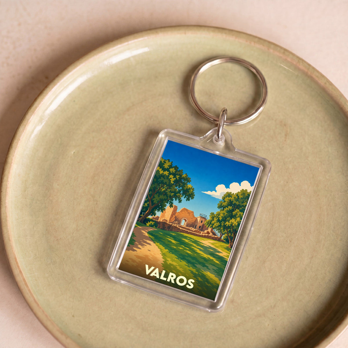 Porte-clés souvenir de la ville de Valros avec une illustration stylisée de ses vestiges historiques.
