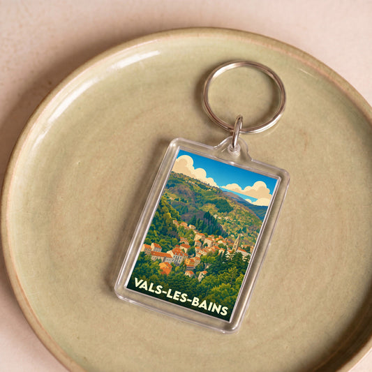 Porte-clés souvenir de la ville de Vals-les-Bains avec une illustration stylisée de ses paysages vallonnés.