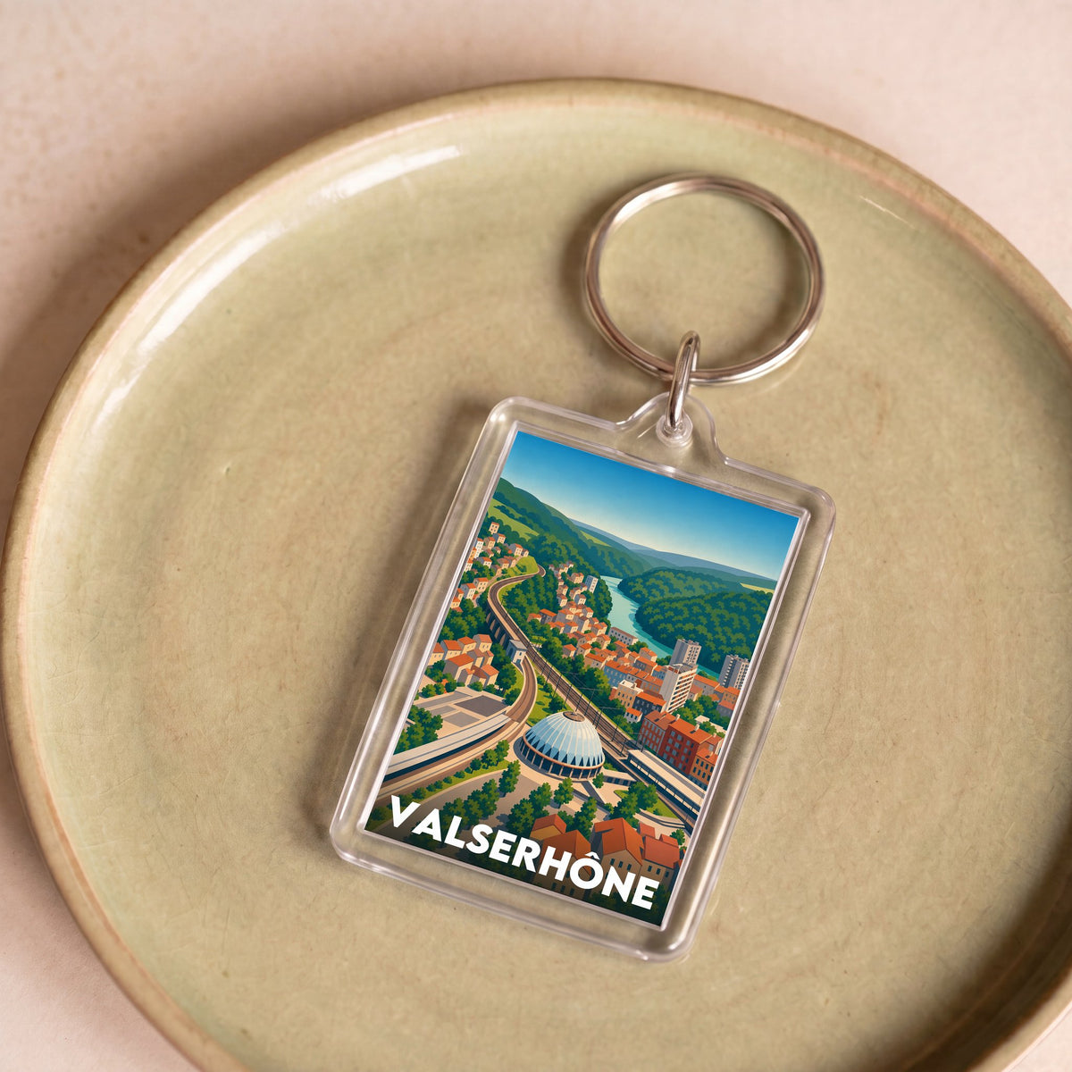 Porte-clés souvenir de la ville de Valserhône avec une illustration stylisée du paysage.
