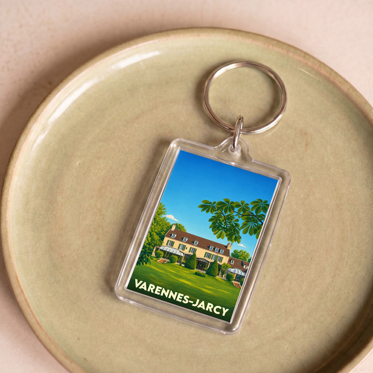 Porte-clés souvenir de la ville de Varennes-Jarcy avec une illustration stylisée d'une grande demeure.