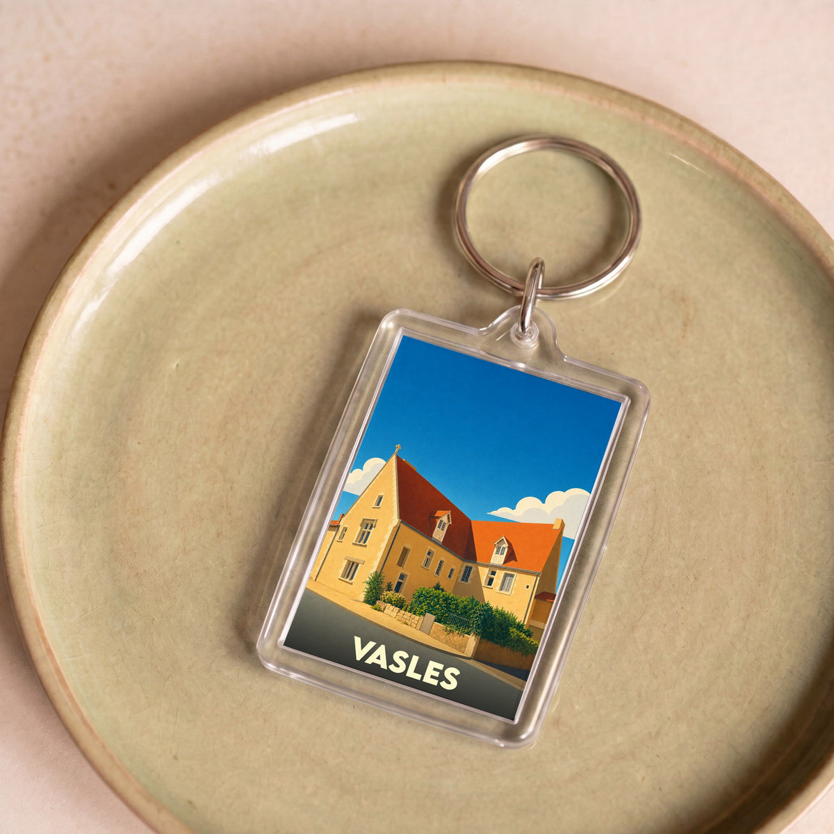Porte-clés souvenir de la ville de Vasles avec une illustration stylisée.