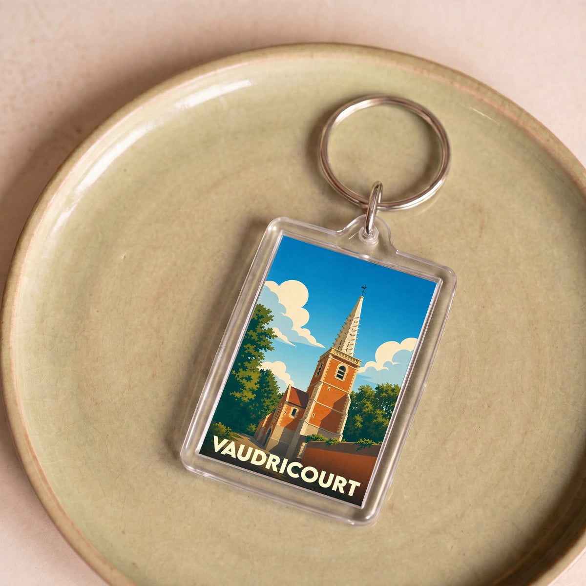 Porte-clés souvenir de la ville de Vaudricourt avec une illustration stylisée de son église.