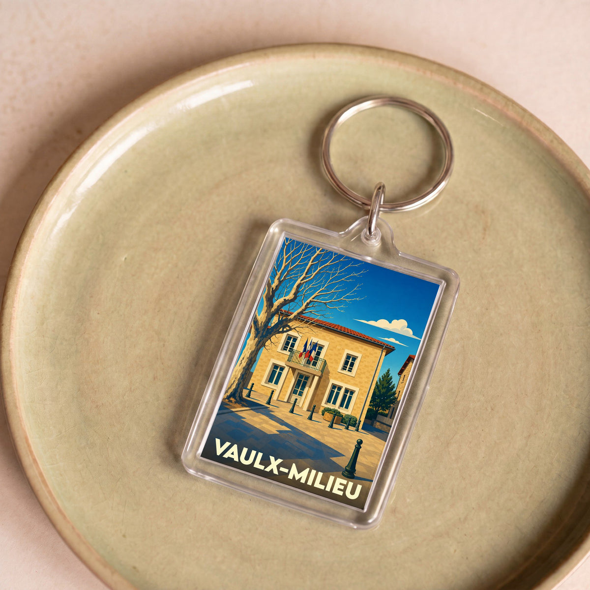 Porte-clés souvenir de la ville de Vaulx-Milieu avec une illustration stylisée de sa mairie.