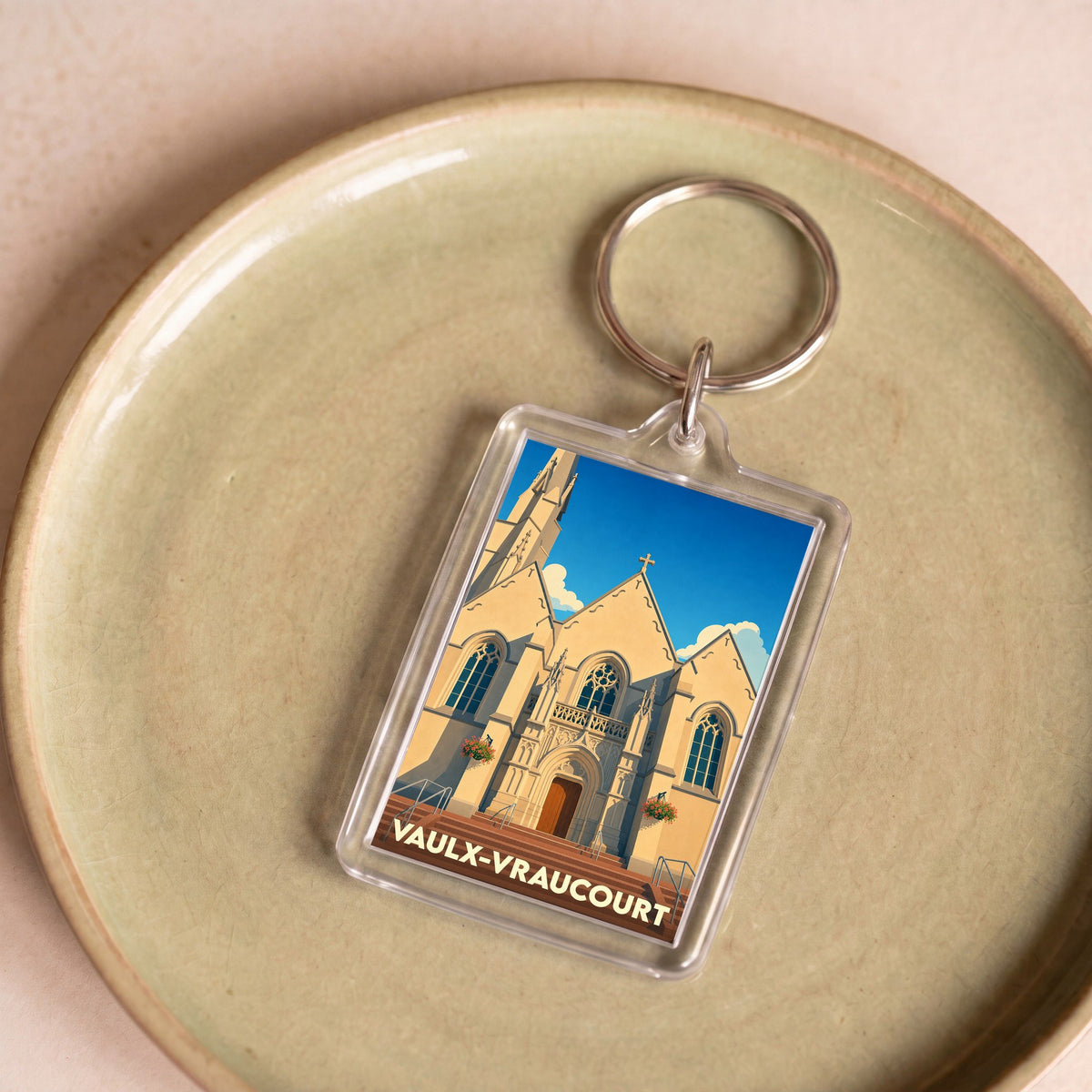 Porte-clés souvenir de la ville de Vaulx-Vraucourt avec une illustration stylisée de son église.