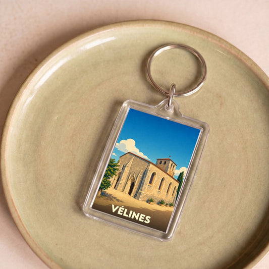 Porte-clés souvenir de la ville de Vélines avec une illustration stylisée de son église.