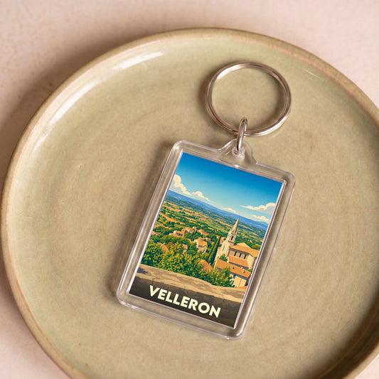 Porte-clés souvenir de la ville de Velleron avec une illustration stylisée de son paysage.