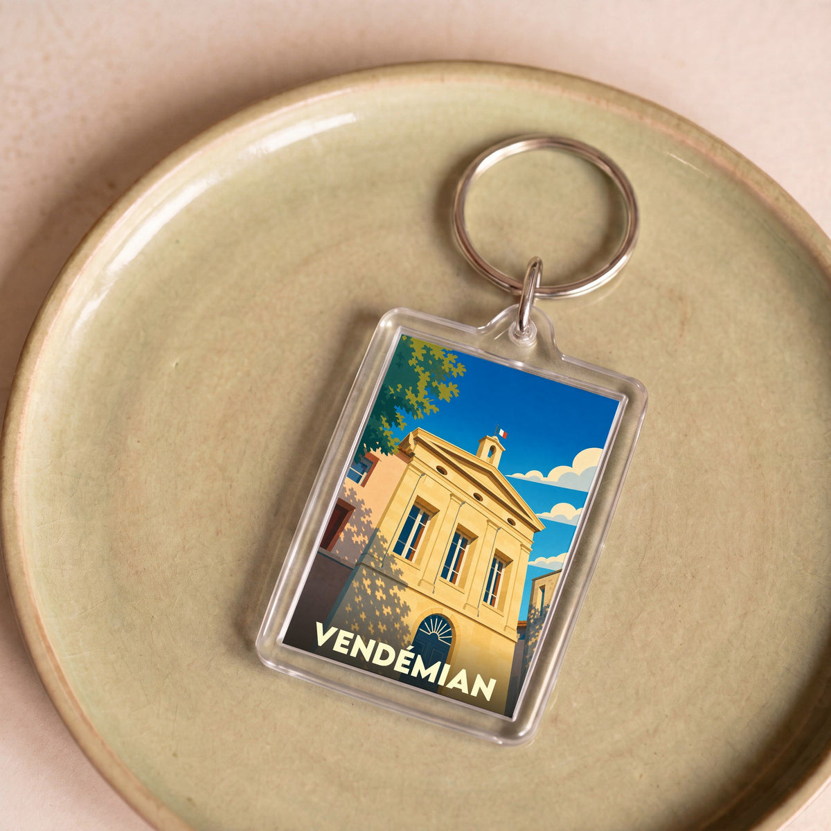 Porte-clés souvenir de la ville de Vendémian avec une illustration stylisée de sa mairie.