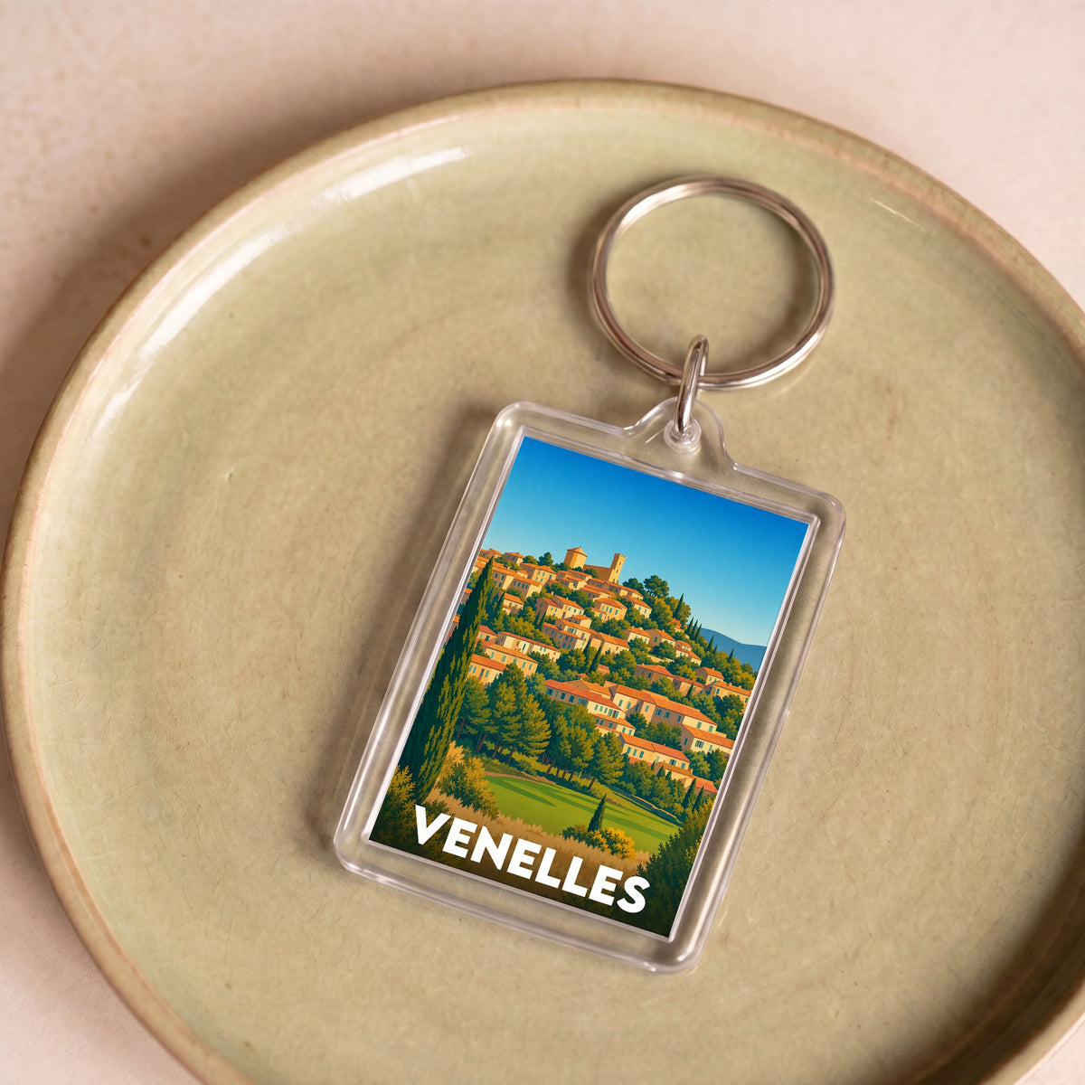 Porte-clés souvenir de la ville de Venelles avec une illustration stylisée.