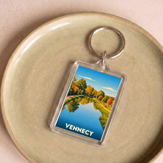 Porte-clés souvenir de la ville de Vennecy avec une illustration automnale de son paysage.