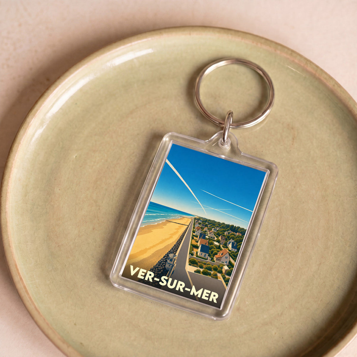 Porte-clés souvenir de la ville de Ver-sur-Mer avec une illustration stylisée du bord de mer.