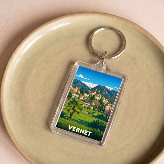 Porte-clés souvenir de la ville de Vernet avec une illustration stylisée de son paysage montagneux.