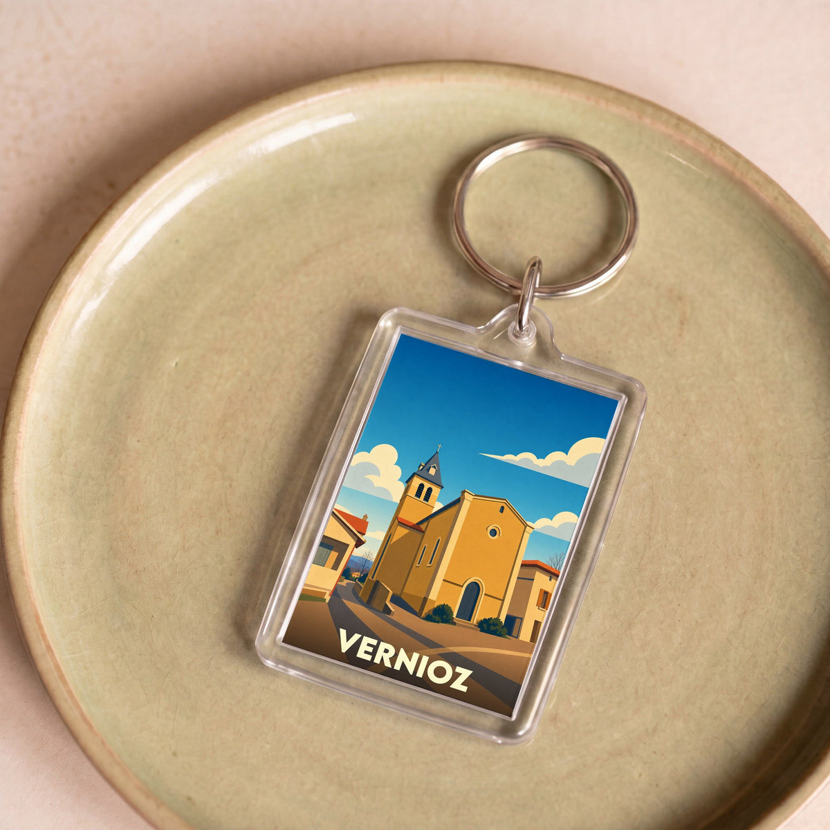 Porte-clés souvenir de la ville de Vernioz avec une illustration stylisée de son église.