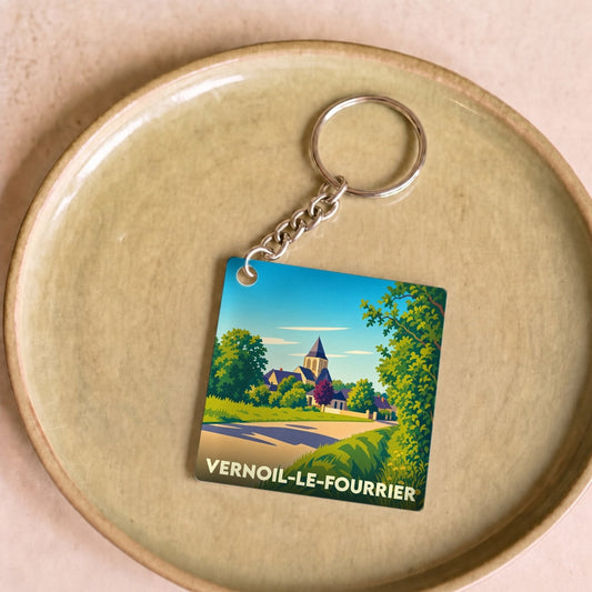 Porte-clés souvenir de la ville de Vernoil-le-Fourrier avec une illustration stylisée de son paysage.