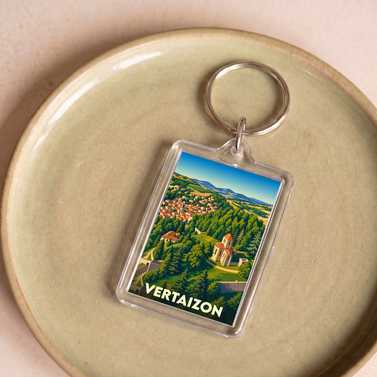 Porte-clés souvenir de la ville de Vertaizon avec une illustration stylisée de son paysage et de ses monuments.